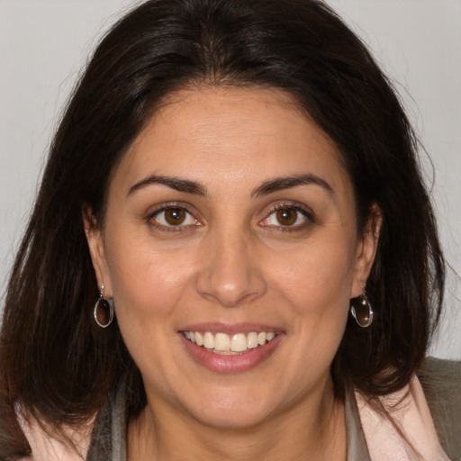 Joyful white adult female with long  brown hair and brown eyes