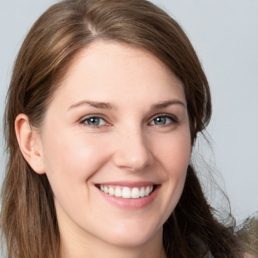 Joyful white young-adult female with long  brown hair and grey eyes