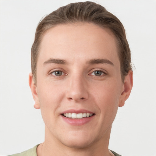 Joyful white young-adult female with short  brown hair and grey eyes