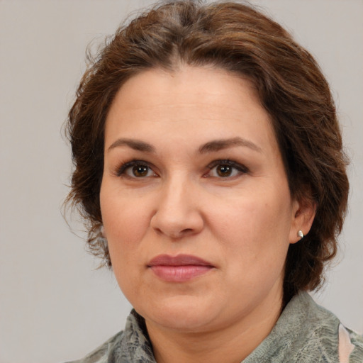 Joyful white adult female with medium  brown hair and green eyes