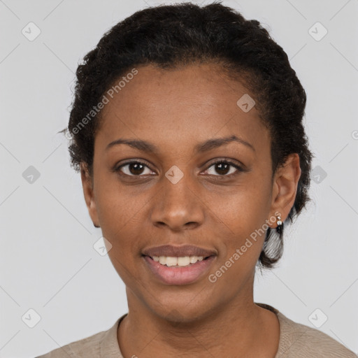 Joyful black young-adult female with short  black hair and brown eyes