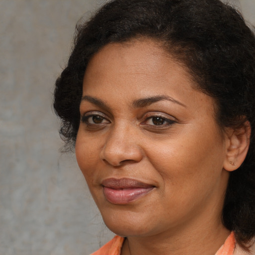 Joyful black adult female with short  brown hair and brown eyes