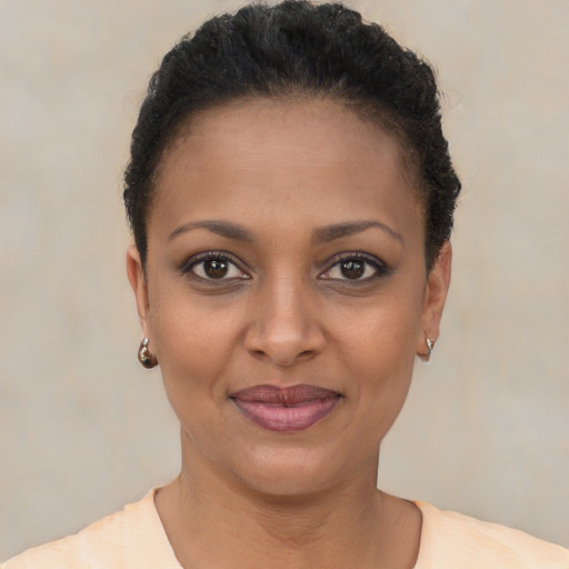 Joyful black young-adult female with short  brown hair and brown eyes