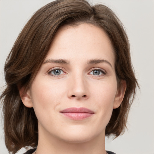 Joyful white young-adult female with medium  brown hair and green eyes