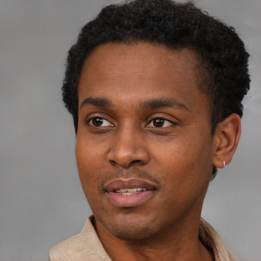 Joyful black young-adult male with short  black hair and brown eyes