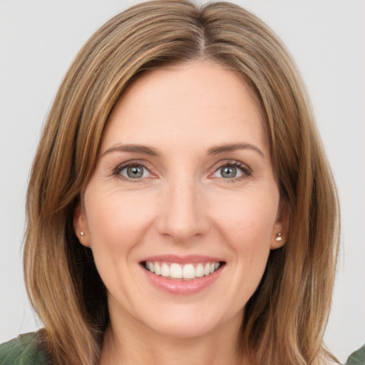 Joyful white young-adult female with medium  brown hair and green eyes