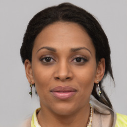 Joyful black adult female with medium  brown hair and brown eyes