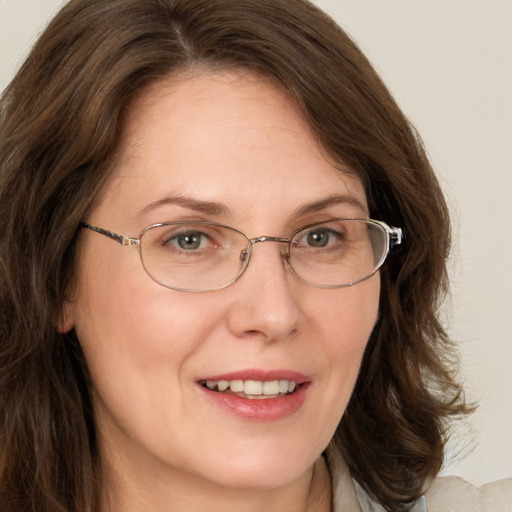 Joyful white adult female with long  brown hair and green eyes