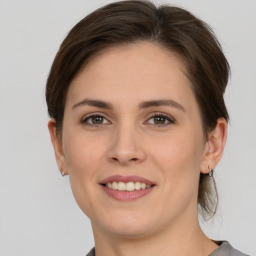 Joyful white young-adult female with medium  brown hair and grey eyes