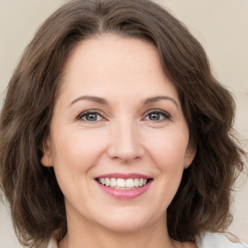 Joyful white young-adult female with medium  brown hair and green eyes