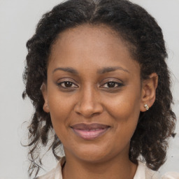 Joyful black adult female with medium  brown hair and brown eyes