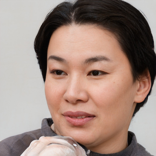 Joyful asian young-adult female with short  brown hair and brown eyes