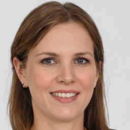 Joyful white young-adult female with long  brown hair and grey eyes