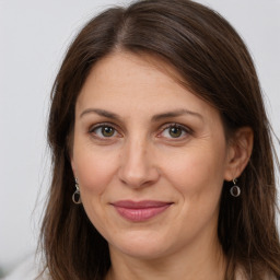 Joyful white adult female with long  brown hair and brown eyes