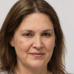 Joyful white adult female with long  brown hair and grey eyes