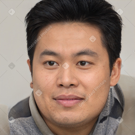 Joyful asian young-adult male with short  brown hair and brown eyes