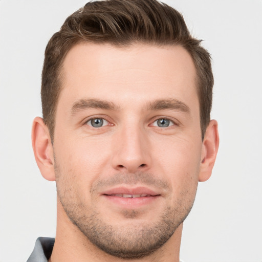 Joyful white young-adult male with short  brown hair and grey eyes