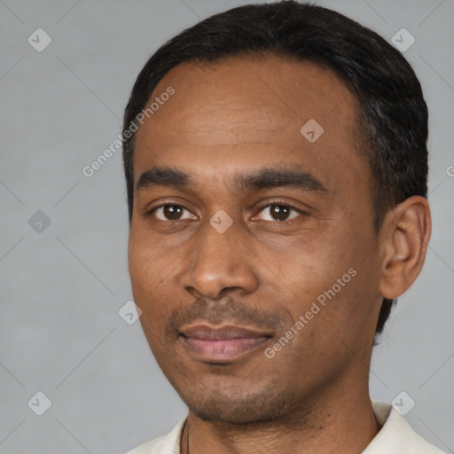 Joyful black young-adult male with short  black hair and brown eyes