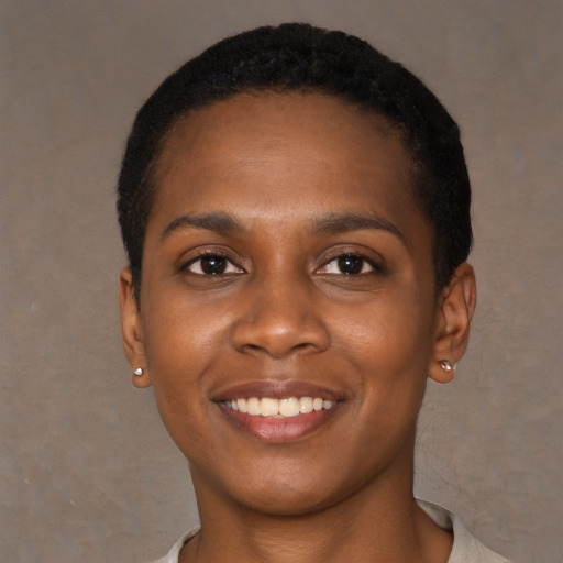 Joyful black young-adult female with short  black hair and brown eyes