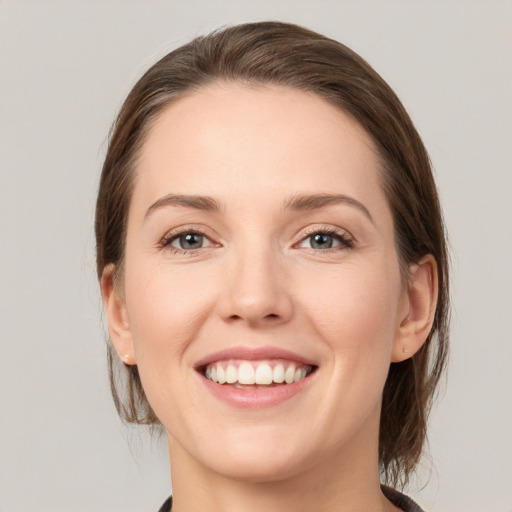 Joyful white young-adult female with medium  brown hair and grey eyes