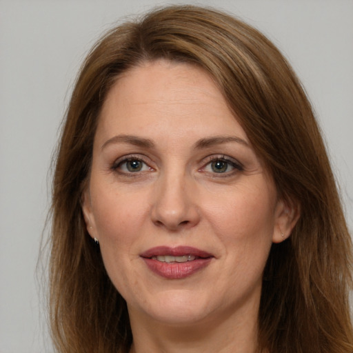 Joyful white adult female with long  brown hair and grey eyes