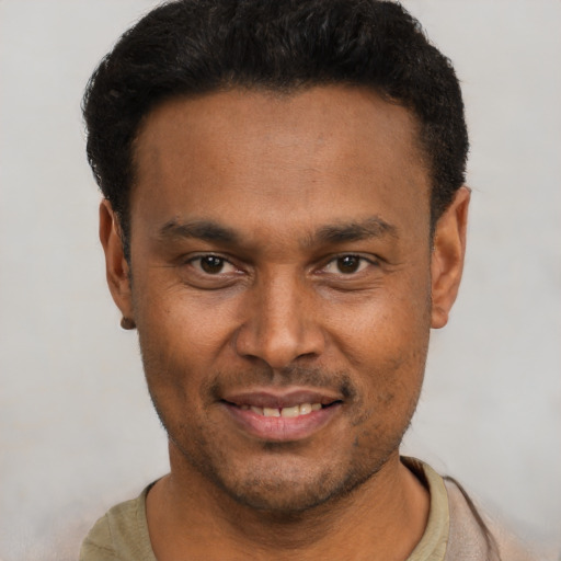 Joyful latino young-adult male with short  brown hair and brown eyes