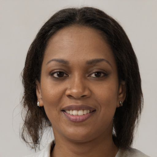 Joyful black adult female with medium  brown hair and brown eyes