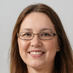 Joyful white adult female with long  brown hair and grey eyes