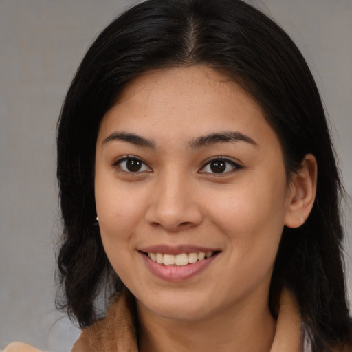 Joyful latino young-adult female with medium  brown hair and brown eyes