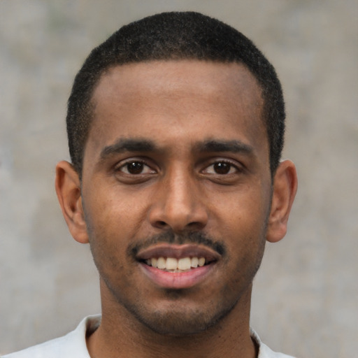Joyful black young-adult male with short  black hair and brown eyes