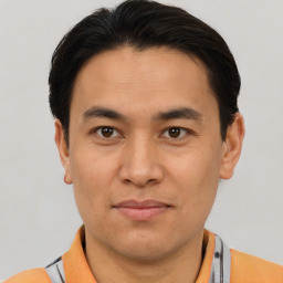 Joyful asian adult male with short  brown hair and brown eyes