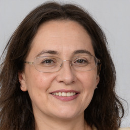 Joyful white adult female with long  brown hair and grey eyes