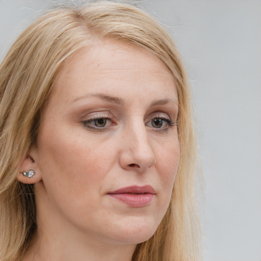 Joyful white young-adult female with long  blond hair and brown eyes