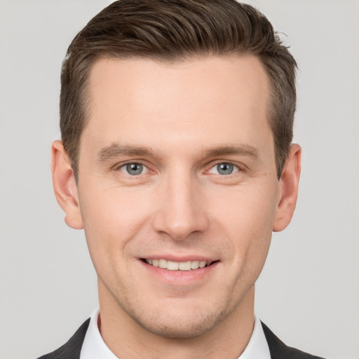 Joyful white young-adult male with short  brown hair and grey eyes