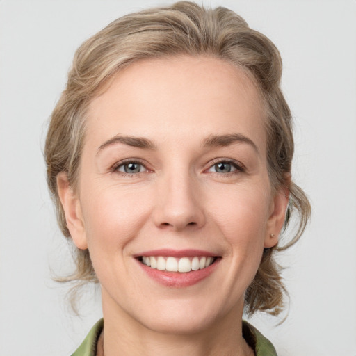 Joyful white young-adult female with medium  brown hair and green eyes