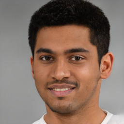 Joyful latino young-adult male with short  black hair and brown eyes
