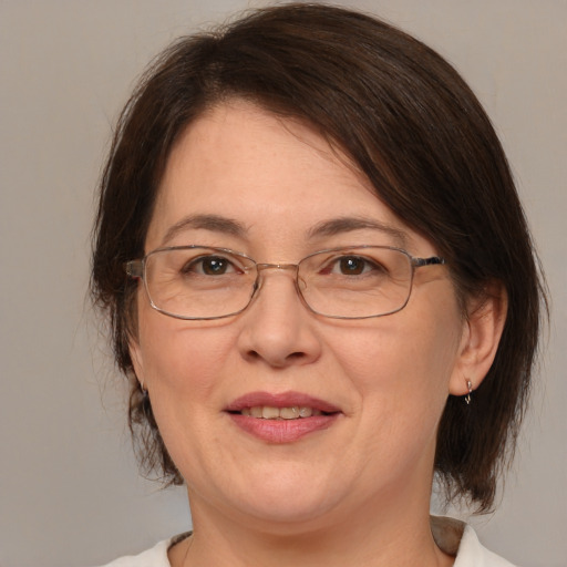 Joyful white adult female with medium  brown hair and brown eyes