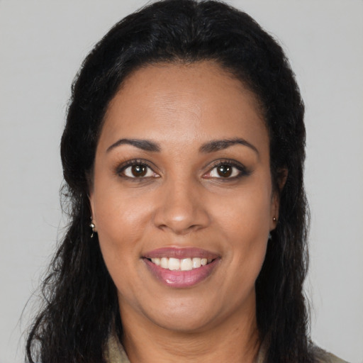 Joyful latino adult female with long  brown hair and brown eyes