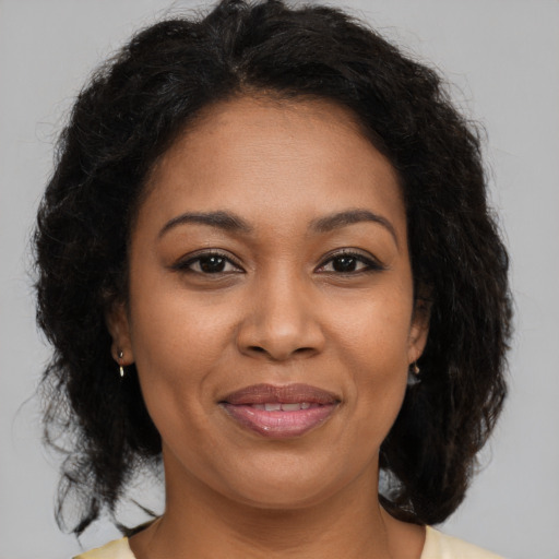 Joyful black adult female with medium  brown hair and brown eyes