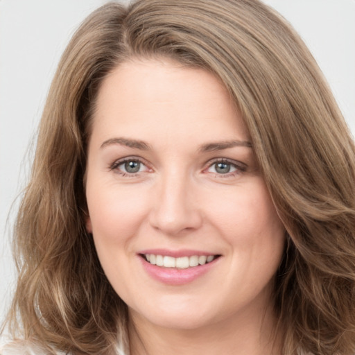 Joyful white young-adult female with long  brown hair and green eyes