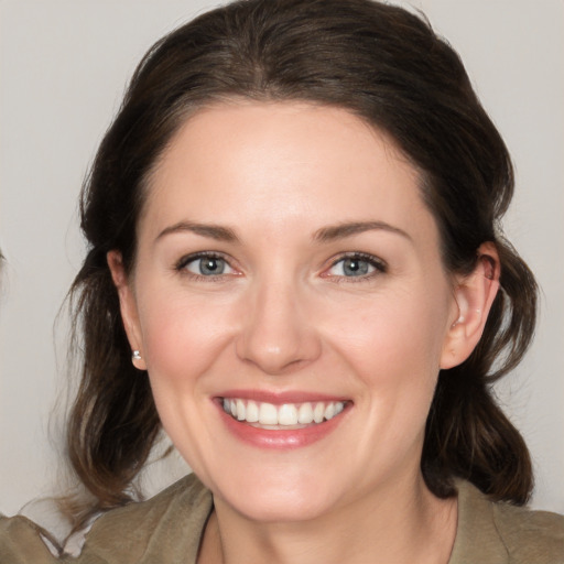 Joyful white young-adult female with medium  brown hair and grey eyes