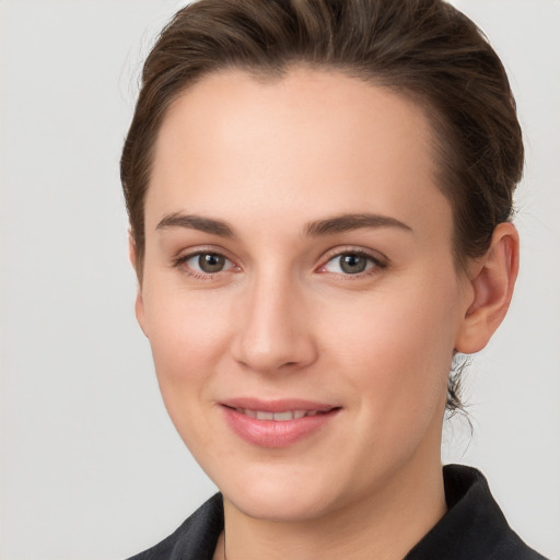 Joyful white young-adult female with short  brown hair and grey eyes