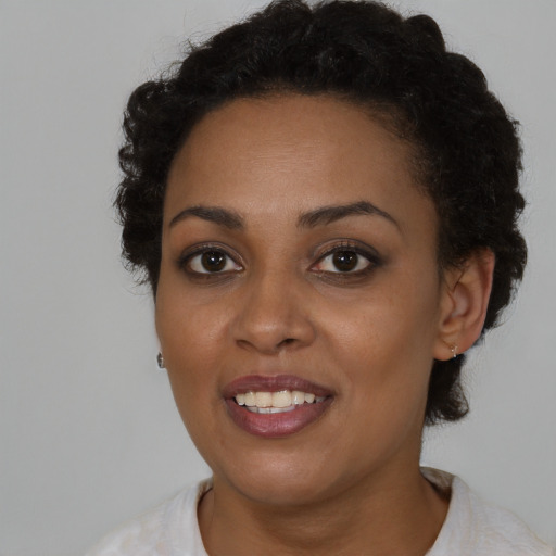 Joyful black young-adult female with short  brown hair and brown eyes