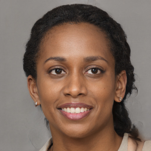 Joyful black adult female with short  black hair and brown eyes