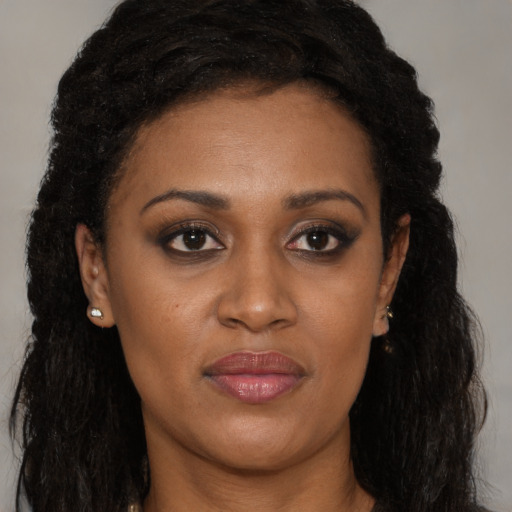 Joyful black young-adult female with long  brown hair and brown eyes