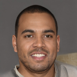 Joyful latino young-adult male with short  brown hair and brown eyes