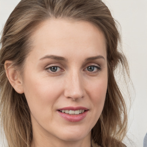 Joyful white young-adult female with long  brown hair and grey eyes