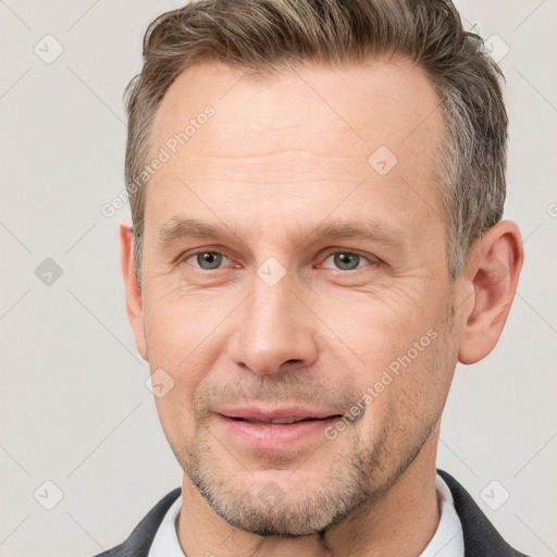 Joyful white adult male with short  brown hair and grey eyes