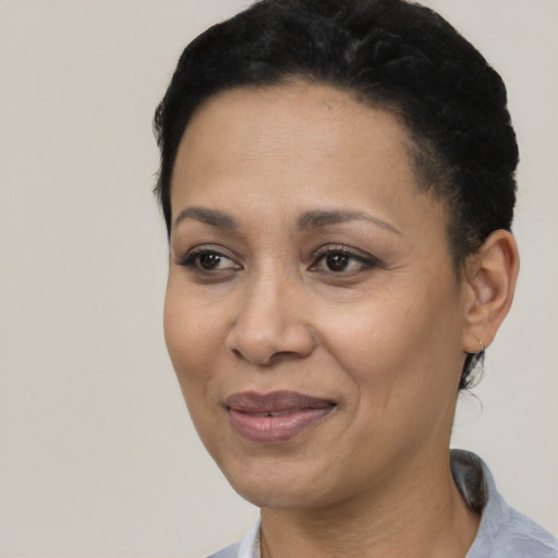 Joyful black adult female with short  black hair and brown eyes