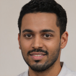 Joyful latino young-adult male with short  black hair and brown eyes